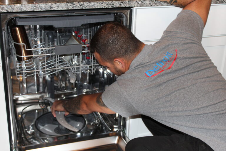 Detroit Appliance employee working repairing a dishwasher.